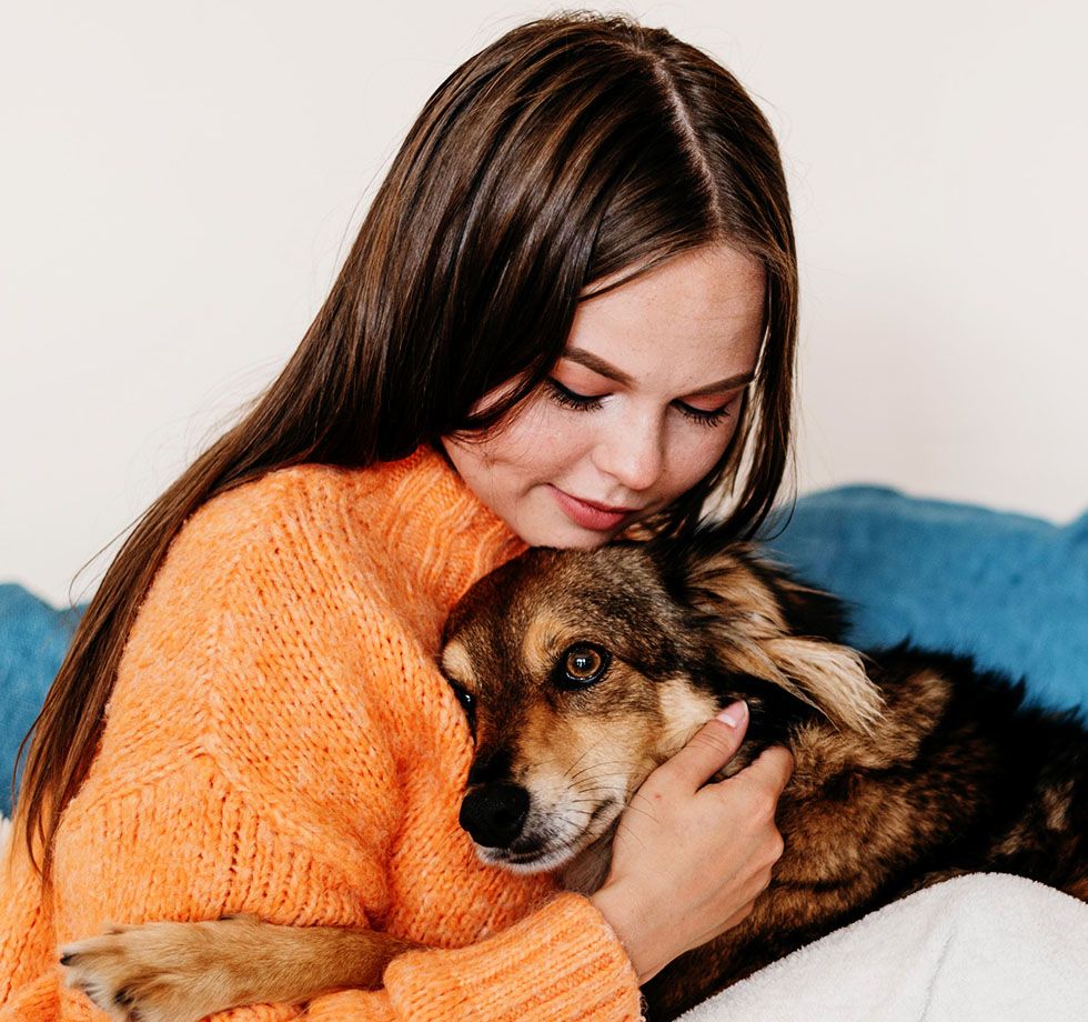 Woman affectionately petting a cute dog